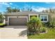 Charming single-story home featuring a well-manicured lawn and attached two-car garage at 13001 Satin Lily Dr, Riverview, FL 33579