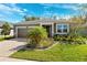 Charming single-story home with manicured lawn, mature landscaping, and a two-car garage at 13001 Satin Lily Dr, Riverview, FL 33579