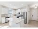 Well-lit kitchen featuring white cabinetry, stainless steel appliances, and a functional center island at 13001 Satin Lily Dr, Riverview, FL 33579