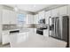Bright kitchen features stainless appliances, white cabinets, and a center island with a quartz countertop at 13001 Satin Lily Dr, Riverview, FL 33579