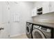 Convenient laundry room with modern washer and dryer, plus upper storage cabinets at 13001 Satin Lily Dr, Riverview, FL 33579