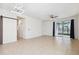 Spacious open-plan living room with tile flooring, ceiling fan, and sliding doors to the backyard at 13001 Satin Lily Dr, Riverview, FL 33579