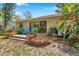 Charming backyard patio with seating, vibrant flowers, and a well-maintained lawn, ideal for outdoor relaxation and entertaining at 1308 Gulfview Woods Ln, Tarpon Springs, FL 34689