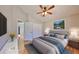 Bright bedroom featuring hardwood floors, ceiling fan, en suite bathroom, and walk in closet at 13719 Artesa Bell Dr, Riverview, FL 33579
