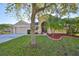 Charming single-Gathering home showcasing a well-manicured lawn, mature trees, and a welcoming two-car garage at 13719 Artesa Bell Dr, Riverview, FL 33579