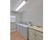 Laundry room with tile floors, window, utility sink, and washer dryer at 13719 Artesa Bell Dr, Riverview, FL 33579
