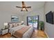 Relaxing main bedroom with a ceiling fan, a serene view of the pool area, and plush bedding at 13719 Artesa Bell Dr, Riverview, FL 33579