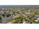 Aerial view of neighborhood featuring trees, homes, and pond with city skyline in the distance on a sunny day at 1432 S Duncan Ave, Clearwater, FL 33756