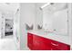 This modern bathroom features a red cabinet under the sink with a large mirror at 145 16Th Ne Ave, St Petersburg, FL 33704