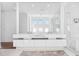 Bright bathroom features a double sink vanity with a large mirror and frameless shower at 145 16Th Ne Ave, St Petersburg, FL 33704