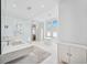 Bright bathroom features a soaking tub, frameless shower, dual sinks, and three windows at 145 16Th Ne Ave, St Petersburg, FL 33704
