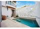 Inviting pool featuring a sun shelf, cascading water feature, travertine tile deck, and a charming garden wall at 145 16Th Ne Ave, St Petersburg, FL 33704