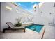 Private pool with a lounge chair, travertine tile deck, and an accent wall with decorative cutouts for a modern look at 145 16Th Ne Ave, St Petersburg, FL 33704