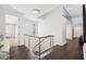 Upstairs hallway featuring wood floors, a modern chandelier, and stainless steel railings offering an airy, modern feel at 145 16Th Ne Ave, St Petersburg, FL 33704