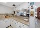 Kitchen area with custom backsplash, white cabinets, and views into the living room at 1456 Ridge Top Way, Clearwater, FL 33765