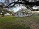 Expansive backyard showcasing a large grassy area, complemented by mature trees, and shed at 1502 S Wiggins Rd, Plant City, FL 33566