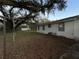 Backyard featuring a large grassy area with trees and a building in the background at 1502 S Wiggins Rd, Plant City, FL 33566