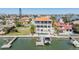 Aerial view of a waterfront home with a pool, balconies, a private dock, and lush tropical landscaping at 16327 Redington Dr, Redington Beach, FL 33708