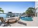 Backyard with a pool, spa, boat lift, fire pit, and bay views at 16327 Redington Dr, Redington Beach, FL 33708