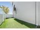 Backyard space with artificial grass and privacy fence offers a low-maintenance outdoor living area at 16327 Redington Dr, Redington Beach, FL 33708