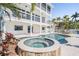 Backyard with a pool, hot tub, outdoor seating, bay view, and exterior spiral staircase at 16327 Redington Dr, Redington Beach, FL 33708