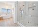 Elegant bathroom boasts a modern shower, soaking tub, chandelier, and a bright view at 16327 Redington Dr, Redington Beach, FL 33708