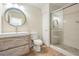 Contemporary bathroom with wood vanity, decorative mirror, and glass-enclosed shower at 16327 Redington Dr, Redington Beach, FL 33708
