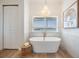 Elegant bathroom features a freestanding tub, stylish chandelier, and water view at 16327 Redington Dr, Redington Beach, FL 33708