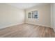 Bright, empty bedroom with hardwood floors and a large window overlooking a water view at 16327 Redington Dr, Redington Beach, FL 33708