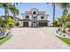 A luxurious Mediterranean-style home boasts a large driveway and well-manicured landscaping at 16327 Redington Dr, Redington Beach, FL 33708
