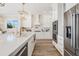 Bright kitchen features stainless appliances, white cabinets, quartz countertops, and wood flooring at 16327 Redington Dr, Redington Beach, FL 33708