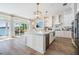 Modern kitchen with an island, stainless appliances, a beautiful waterfront view, and hardwood floors at 16327 Redington Dr, Redington Beach, FL 33708