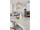 Close-up of the bright kitchen features, white cabinets, quartz countertops, and gold hardware at 16327 Redington Dr, Redington Beach, FL 33708
