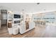 Bright open-concept living and dining area, featuring wood floors, large windows, and chic modern furniture at 16327 Redington Dr, Redington Beach, FL 33708