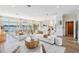 Bright, open-concept living room with waterfront views, elegant furniture, and hardwood flooring at 16327 Redington Dr, Redington Beach, FL 33708