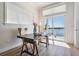 Bright office with a wooden desk, view of the water, and sliding glass doors to a balcony at 16327 Redington Dr, Redington Beach, FL 33708