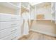Bright walk-in closet with custom shelving, drawers, and a hanging white robe at 16327 Redington Dr, Redington Beach, FL 33708