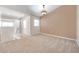 Bright and airy living room featuring neutral carpet, fresh paint, and a contemporary light fixture at 2028 Kings Palace Dr # 202, Riverview, FL 33578