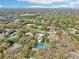 Aerial shot showcasing the property's lush surroundings, with a tennis court and mature trees at 2112 Laurence Dr, Clearwater, FL 33764