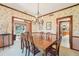 Well-lit dining room featuring a wooden dining set and floral wallpaper with wood trim at 2112 Laurence Dr, Clearwater, FL 33764