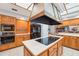 Modern kitchen with stainless steel appliances, a large island, and wood cabinets, plus tile floors at 2112 Laurence Dr, Clearwater, FL 33764