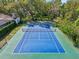 Aerial view of a private tennis court surrounded by lush greenery and mature trees at 2112 Laurence Dr, Clearwater, FL 33764