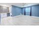 Spacious blue bedroom featuring a ceiling fan, tile floors, and modern finishes at 2121 Park N St, St Petersburg, FL 33710