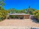 Charming home with a brick driveway, surrounded by lush tropical plants and a shaded pergola entrance at 2121 Park N St, St Petersburg, FL 33710