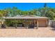 Charming single-story home featuring a brick driveway, lush greenery, and a cozy front porch at 2121 Park N St, St Petersburg, FL 33710