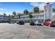 Multi-story condo complex with ample parking, featuring mature palm trees and nicely maintained landscaping at 2401 Ecuadorian Way # 57, Clearwater, FL 33763