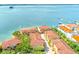 Community aerial view of bayfront property with red tile roofs and mature landscaping at 250 Seagate Ct, Dunedin, FL 34698