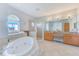 Bright bathroom with large soaking tub, glass enclosed shower, and dual sinks at 250 Seagate Ct, Dunedin, FL 34698