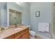 Bathroom with granite vanity, toilet, large mirror, and glass enclosed shower at 250 Seagate Ct, Dunedin, FL 34698