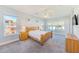 Bright bedroom with carpet, ceiling fan, and windows with a view of the community at 250 Seagate Ct, Dunedin, FL 34698